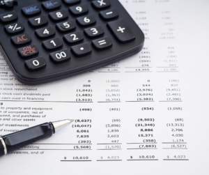 balance sheet, calculator and pen