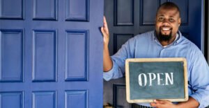 restaurant owner holding an open sign