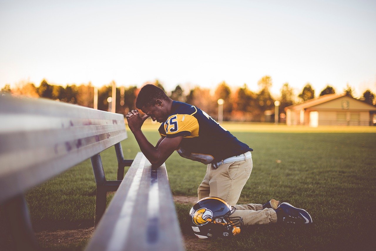 athelete worried and kneeling at a bench athelete worried and kneeling at a bench