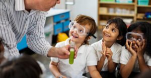 Educator teaching young students via a science experiment