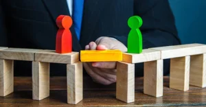 Sales tax nexus shown as a bridge between two people using wooden toy pieces