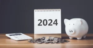 tax refund for 2024 represented by a calculator, calendar, a piggy bank and a pile of coins