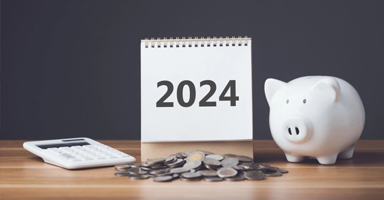 tax-refunds-for-2024 tax refund for 2024 represented by a calculator, calendar, a piggy bank and a pile of coins