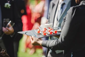 waiter holding a tray of food at a catered event