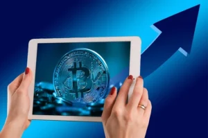 bitcoin shown on a mobile tablet and a graph behind showing growth