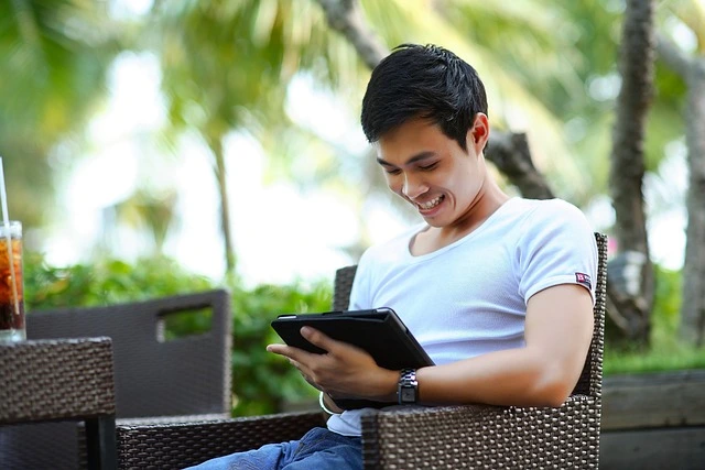 man-looking-at-his-portfolio-on-a-tablet-and-smiling man-looking-at-his-portfolio-on-a-tablet-and-smiling