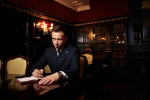 person sitting in his library and writing his will