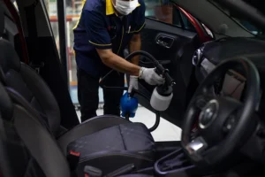 a worker cleaning a car at a car wash
