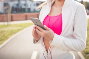 woman checking Fitness App during her run outdoors