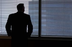 Employer looking out the window thinking about State Paid Family and Medical Leave Programs