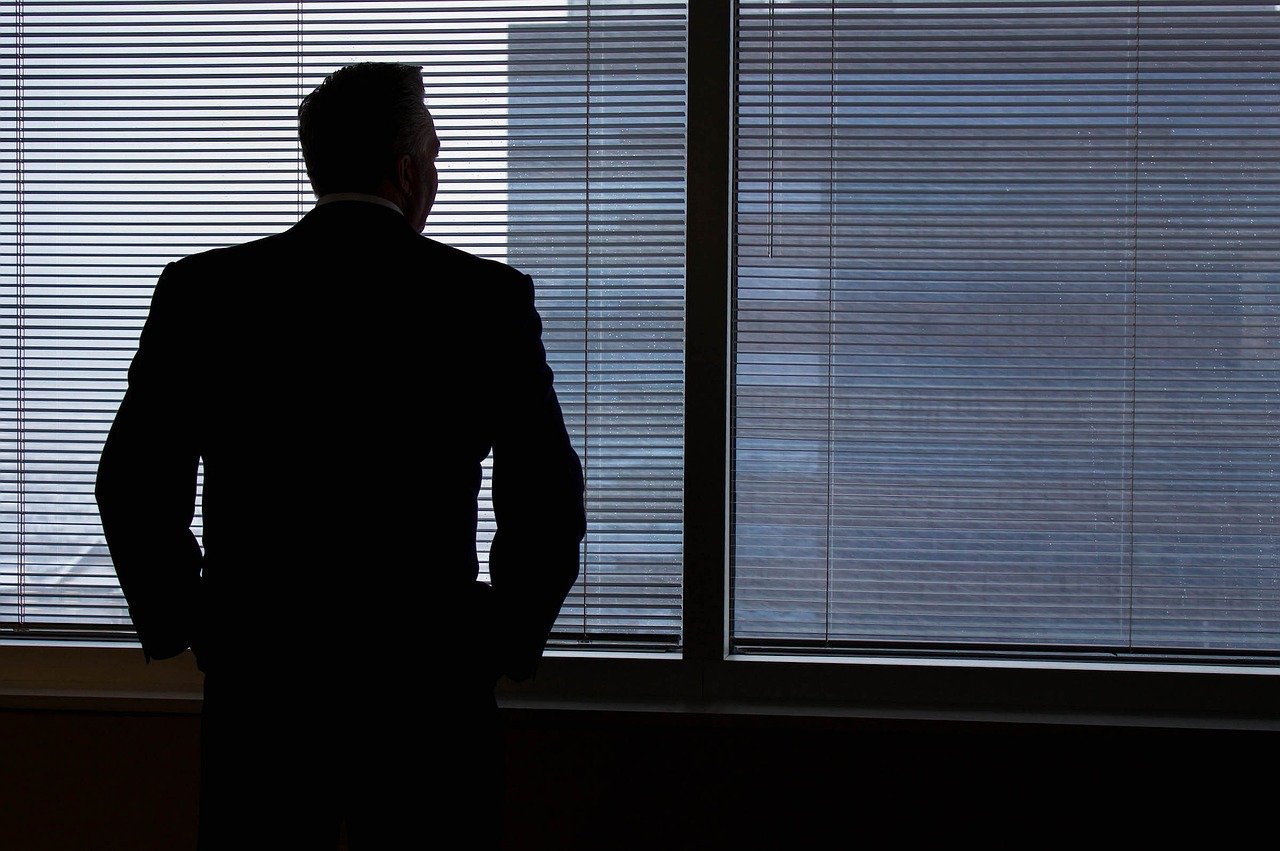 Employer looking out the window thinking about State Paid Family and Medical Leave Programs Employer looking out the window thinking about State Paid Family and Medical Leave Programs