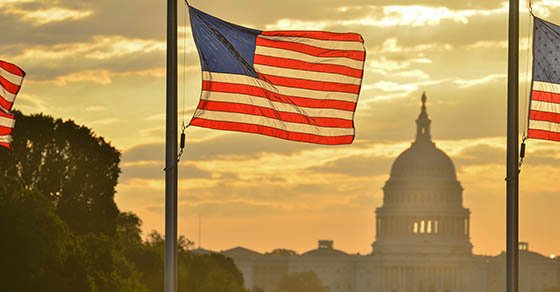 United,States,Capitol,Dome,Silhouette,And,The,National,Flags,Of capitol hill behind the american flag