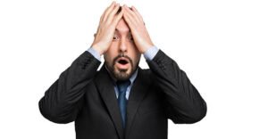 a generic picture of a desperate businessman holding his head.