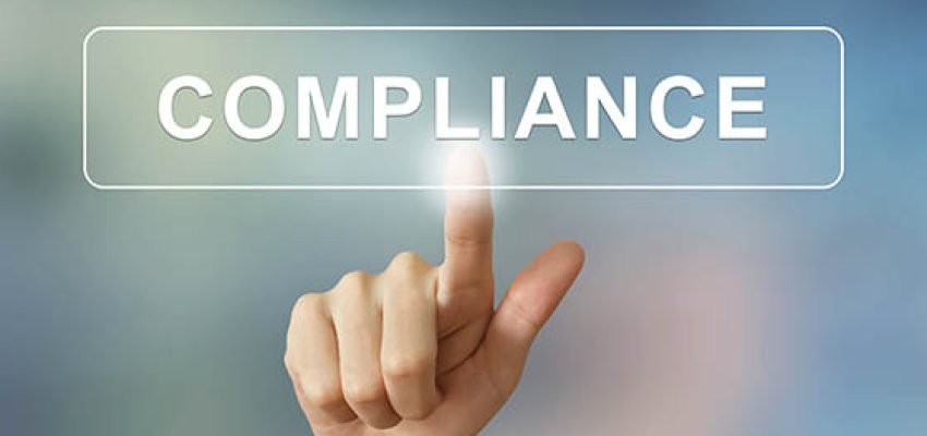 business hand pushing compliance button on blurred background