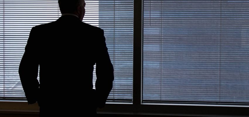 Employer looking out the window thinking about State Paid Family and Medical Leave Programs