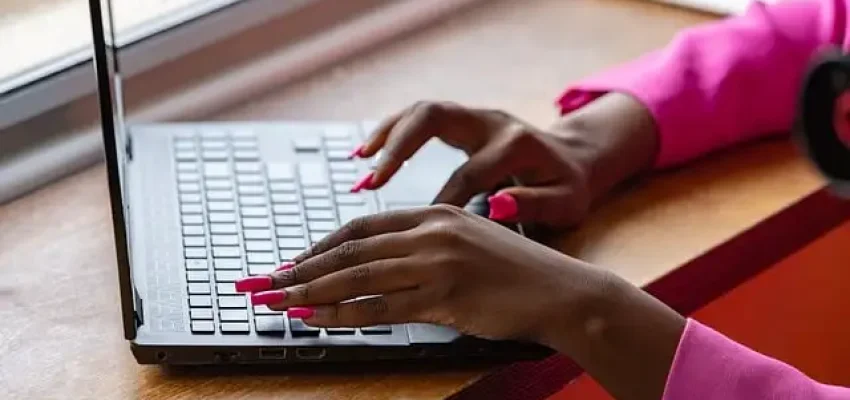 a woman inputs data into a billing software on a laptop