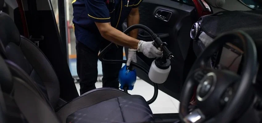 a worker cleaning a car at a car wash