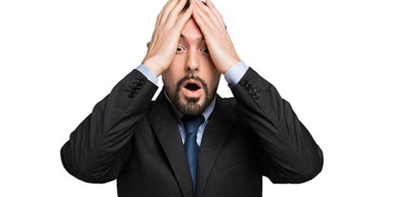 a generic picture of a desperate businessman holding his head.