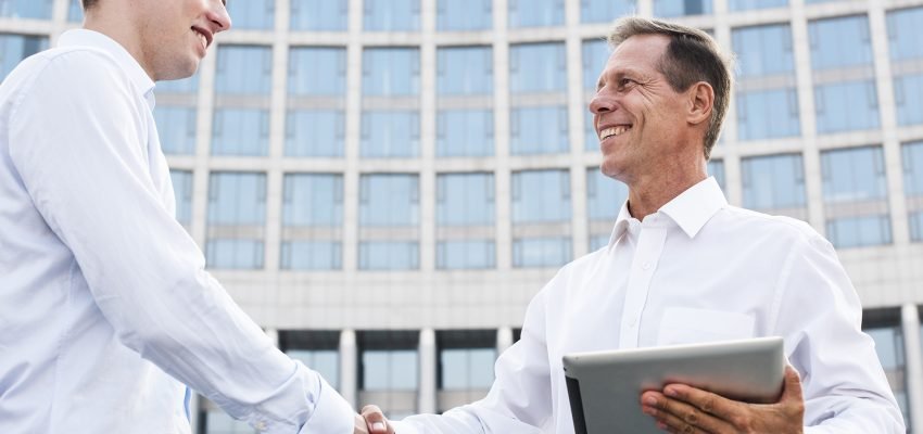 businessmen-shaking-hands-near-building