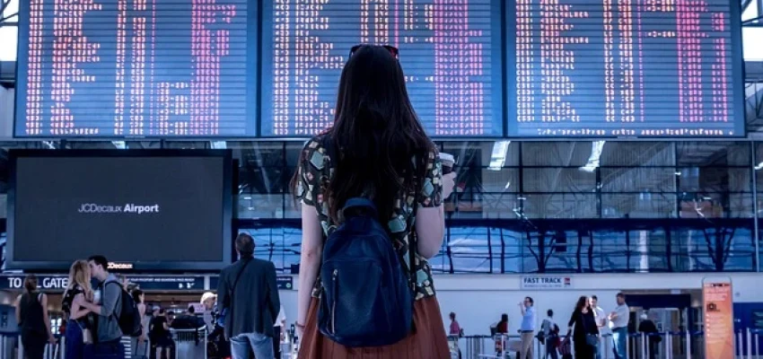 female traveler looking at the schedule in a busy airport