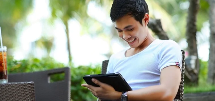 man-looking-at-his-portfolio-on-a-tablet-and-smiling